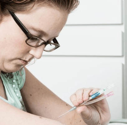 Vrouw prikt met injectienaald 