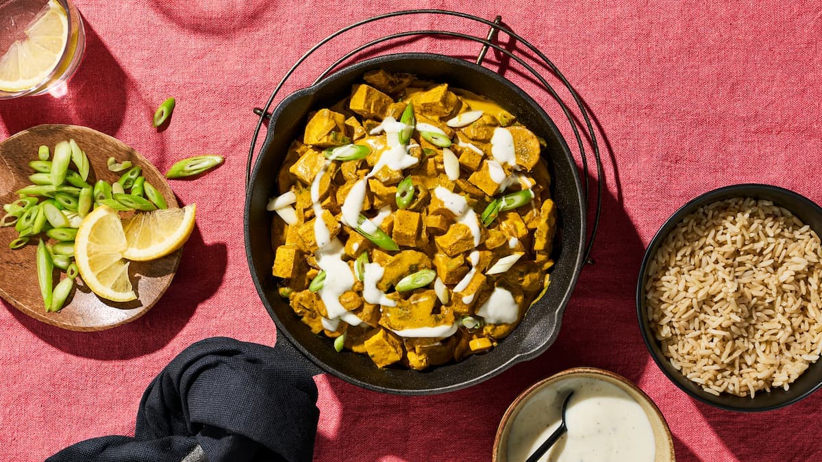 Tofu-paddenstoelencurry met rijst in een kom, met romige saus, paddenstoelen en blokjes tofu.
