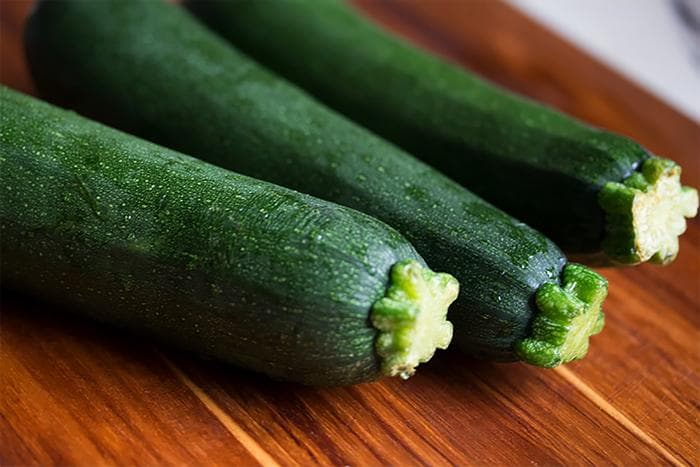 3 courgettes op houten ondergrond voor zoutarm gevulde courgettes