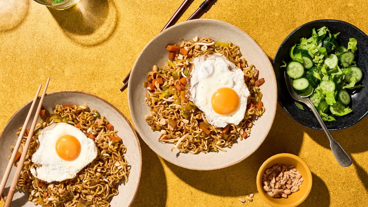 Bami met spiegelei, geserveerd als Aziatisch noedelgerecht met groenten en een gebakken ei erbovenop op een bord