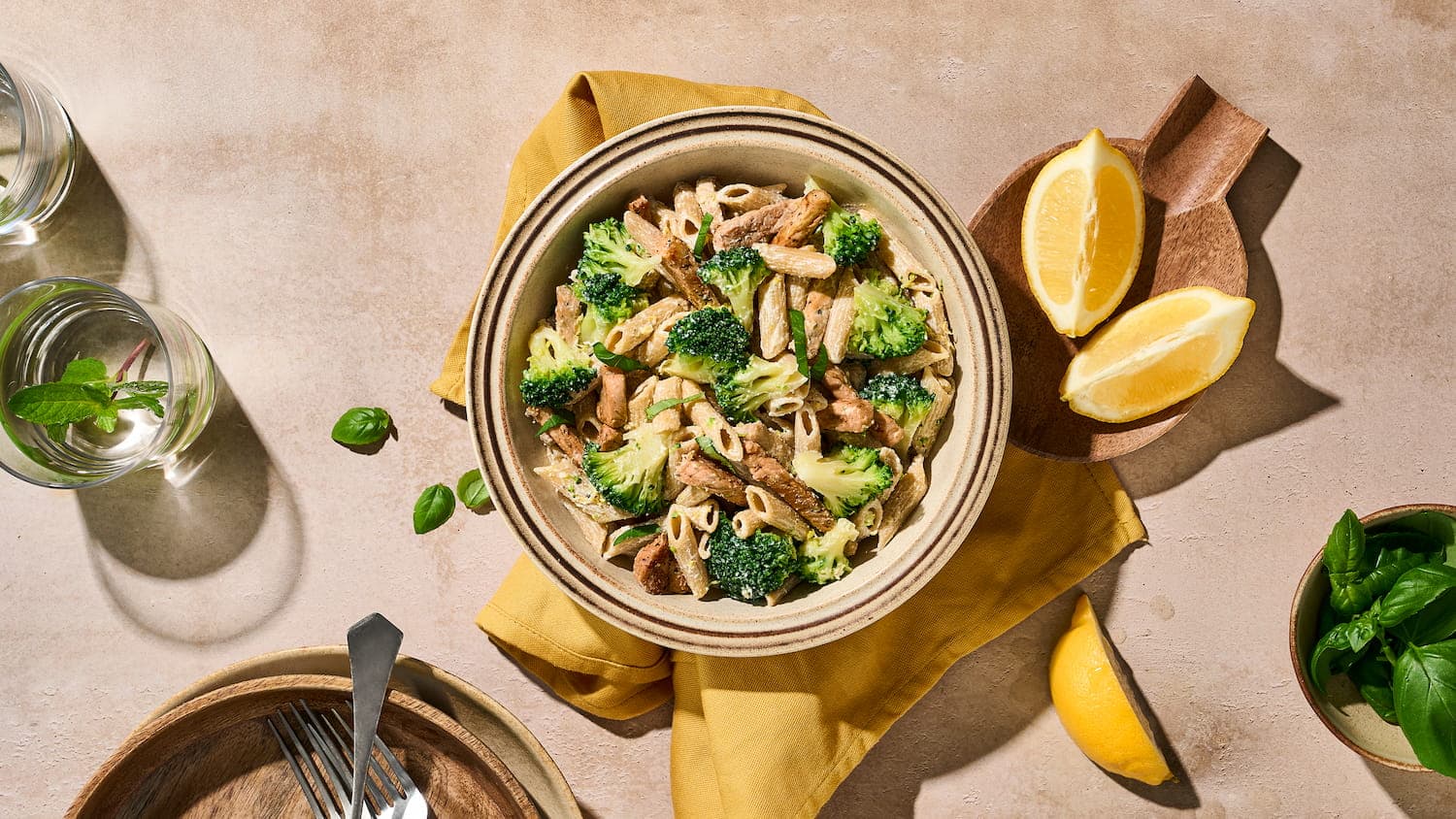 Broccoli met penne, varkensvleesreepjes en citroen, een kleurrijke pastamaaltijd met groenten en vlees op een bord