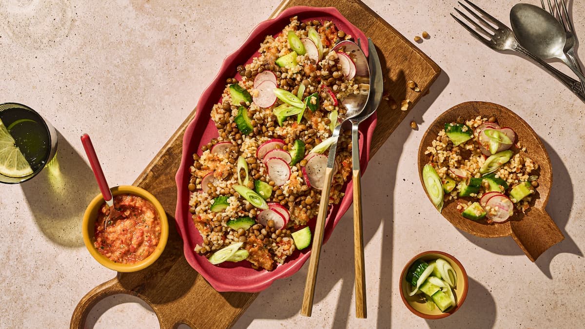 Frisse linzensalade met bulgur, kleurrijk geserveerd met groenten, kruiden en een lichte dressing