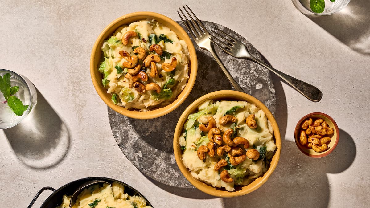 Stamppot groene kool met spicy noten, geserveerd als warme stamppot met knapperige notentopping op een bord