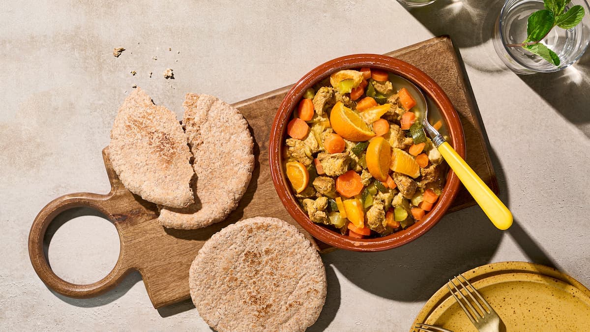Stoofpot met kalkoen en sinaasappel in een schaal, met malse kalkoenstukjes in saus en partjes sinaasappel