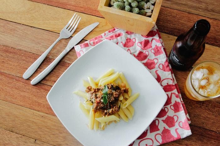 Zoutarme winterse bolognese saus met pasta op een wit bord